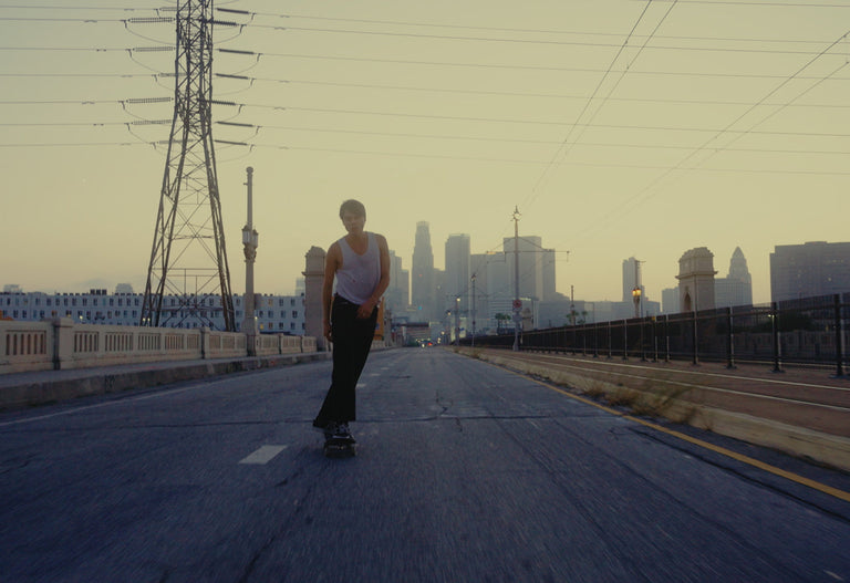 Person skateboarding with a city skyline in the background