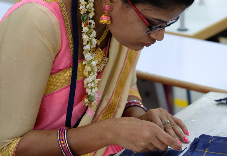 Woman in traditional attire working on a craft project
