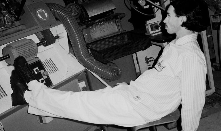 Person in a white lab coat working with equipment in a laboratory setting