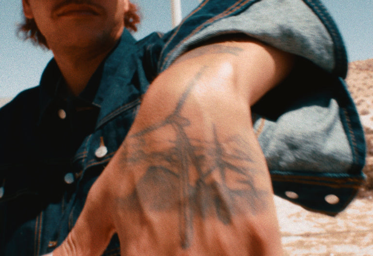 Person with a tattoo on their hand outdoors