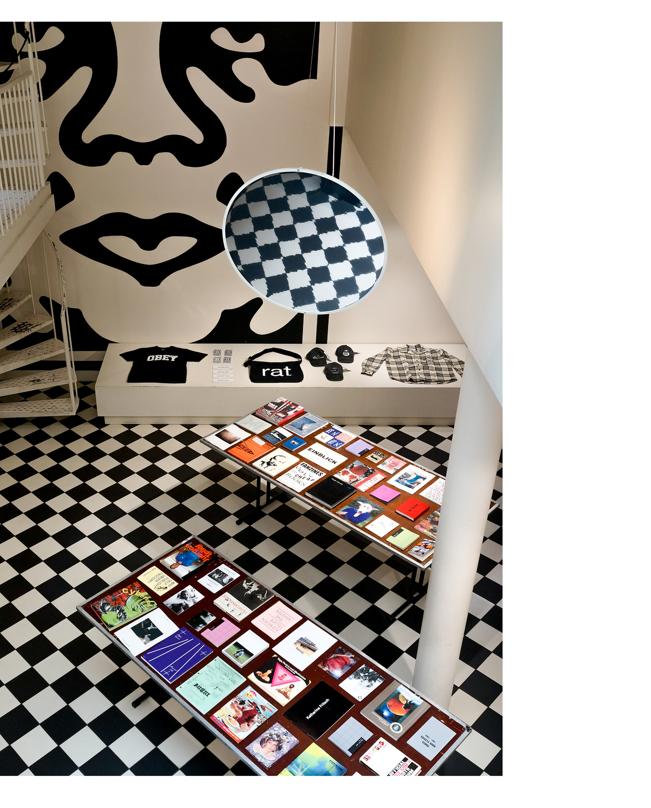 Obey Amsterdam store with two tables of books and Icon face in the background
