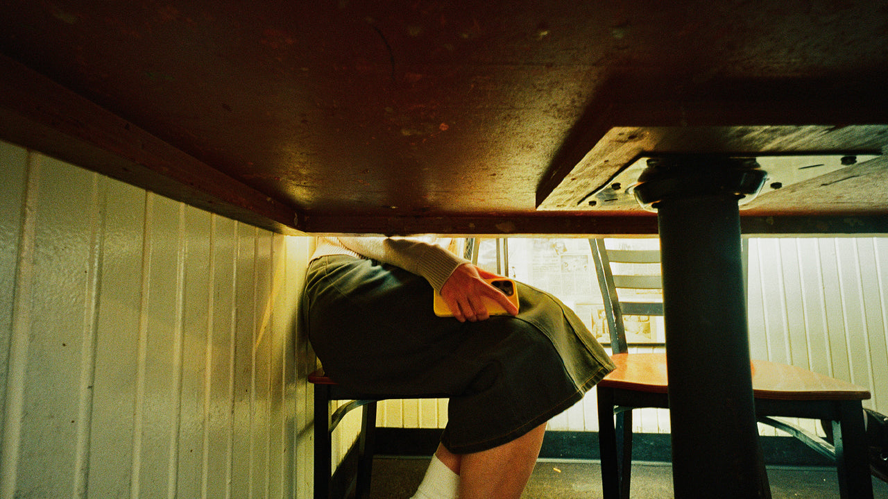 Person sitting under a table in a dimly lit room
