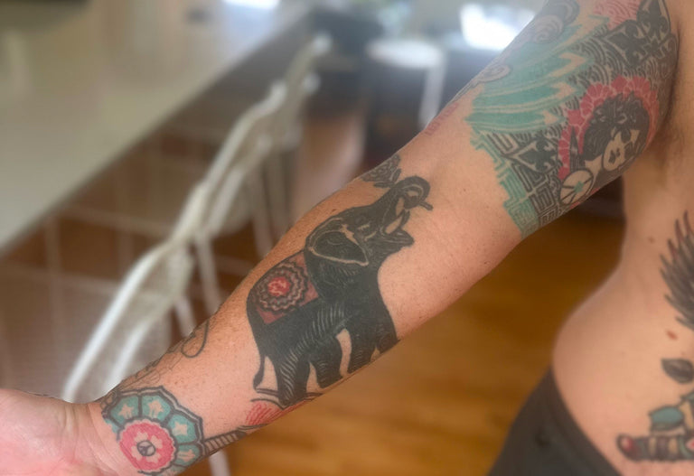 Person with tattoos on their arm in an indoor setting