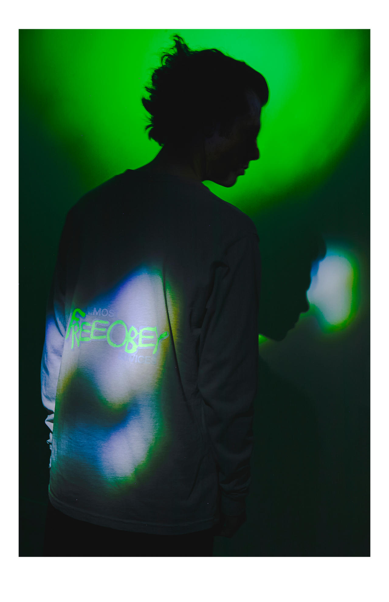 Person wearing a shirt with a glowing design against a green background