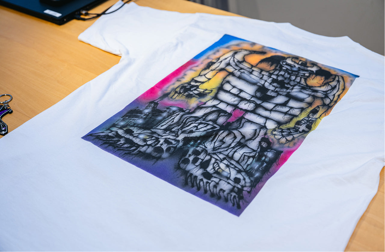 White t-shirt with a colorful graphic design .