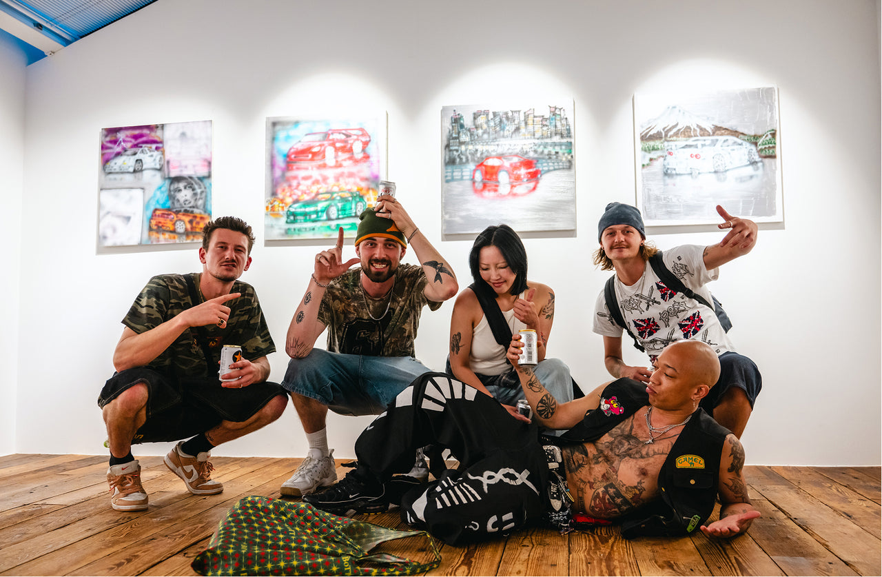 Five people posing together in a room with artwork on the walls.